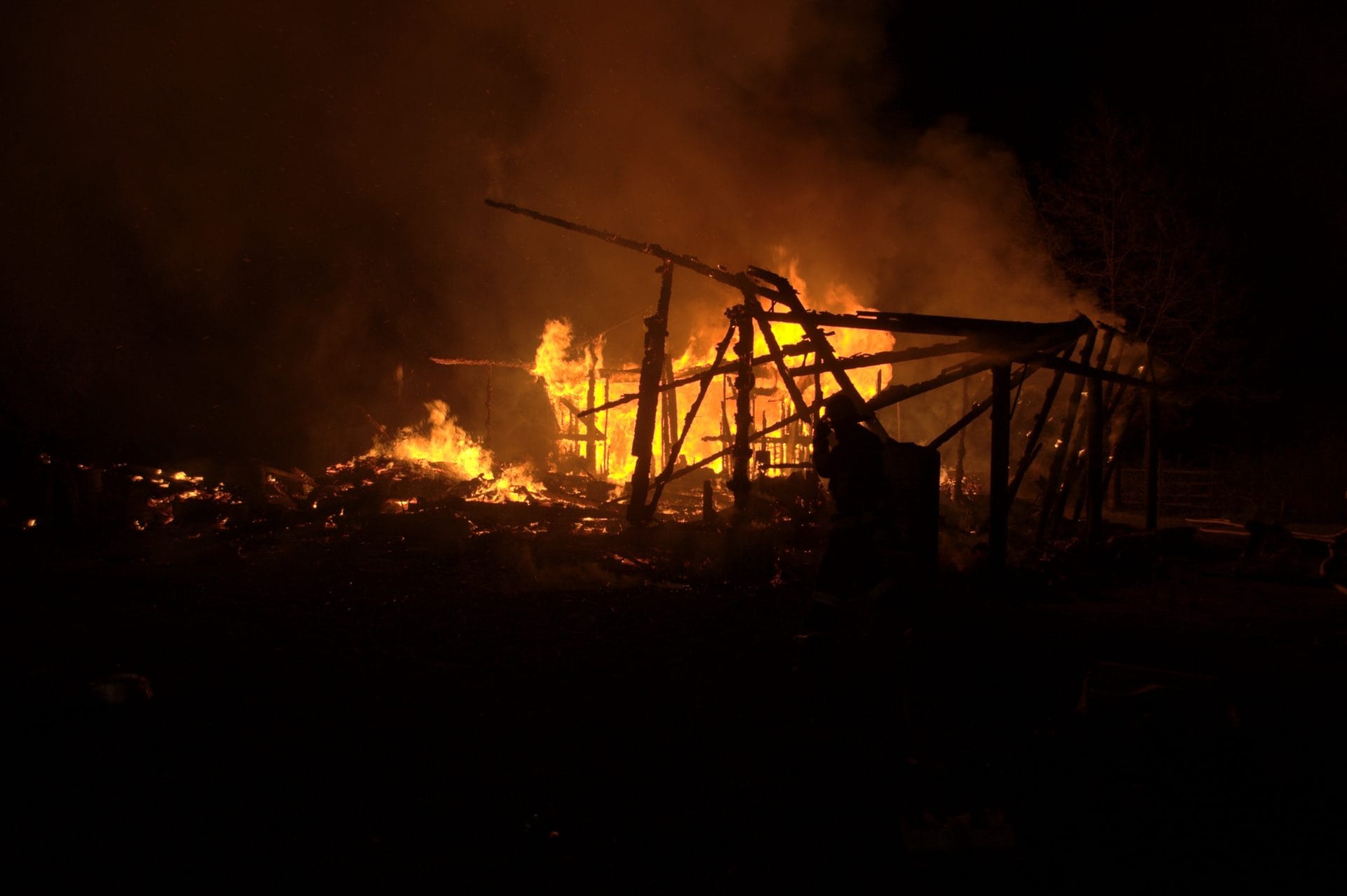 NIKON CORPORATION NIKON D5000 · 22 mm · f/4.5 · 1/100 s A nighttime scene of a large fire burning in the dark, with flames and smoke rising into the sky.